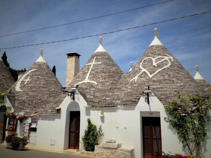 The conical trulli roofs are decorated with various spiritual characters